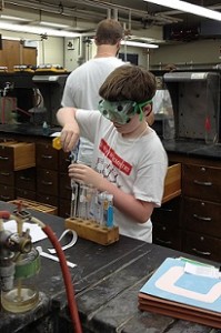 A student pours a substance into a test tube during lab work.