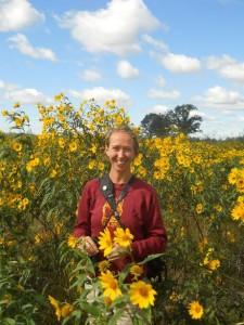 Amy Alsted stands in a field of sunflowers.